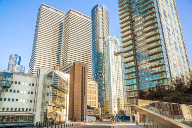  Londra, İngiltere - 14 Haziran 2025: Canary Wharf manzaralı güney rıhtımı gün batımında. Ofis gökdelenleri ve konut kuleleri 