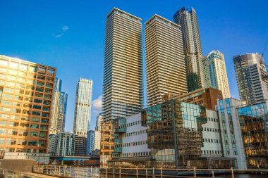  Londra, İngiltere - 14 Haziran 2025: Canary Wharf manzaralı güney rıhtımı gün batımında. Ofis gökdelenleri ve konut kuleleri 