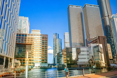  Londra, İngiltere - 14 Haziran 2025: Canary Wharf manzaralı güney rıhtımı gün batımında. Ofis gökdelenleri ve konut kuleleri 