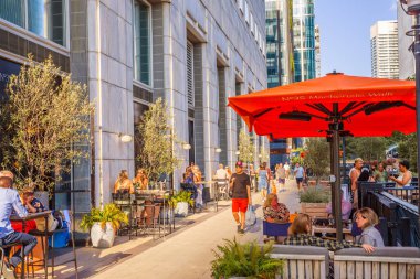 Londra, İngiltere - 14 Haziran 2025: Canary Wharf 'taki Eden rıhtımının yanındaki restoranda gün batımında dinlenen insanlar. 