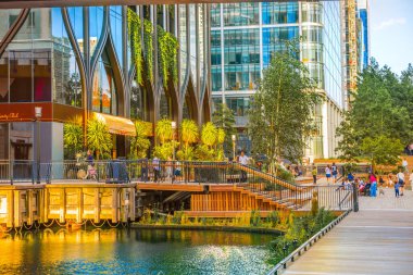 Londra, İngiltere - 14 Haziran 2025: Gün batımında Eden rıhtımında yüzen bahçe uzun çalışma gününden sonra dinlenen insanlarla 