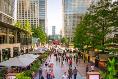 Londra, İngiltere - 14 Haziran 2025: İnsanlar gün batımında metro istasyonu girişinin yanında yürüyorlar, Canary Wharf 