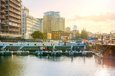 Londra, İngiltere - 14 Haziran 2025: Canary Wharf 'ta gün batımında North Dock manzarası. Rıhtımda dinlenen ve eğlenen insanlar 