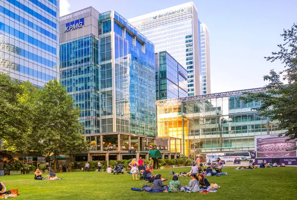 Londra, İngiltere - 14 Haziran 2025: Bir grup insan Kanada meydanında piknik yapıyor. Gün batımında Kanarya İskelesi.