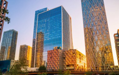 Londra, İngiltere - 18 Haziran 2025: Günbatımında Canary Wharf 'taki ofis ve konut binalarıyla Eden limanı manzarası. 