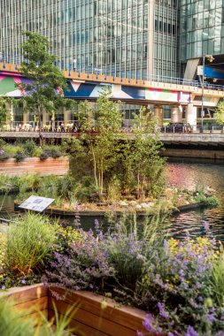 Londra, İngiltere - 14 Haziran 2025: Gün batımında Eden rıhtımında yüzen bahçe uzun çalışma gününden sonra dinlenen insanlarla 