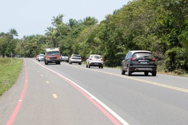 İlheus, Bahia, Brezilya - 7 Ekim 2022: Güney Bahia 'daki Ilheus ve Itacare şehirleri arasında eyalet otoyolu boyunca seyahat eden araçların görüntüsü.