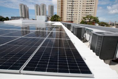 Salvador, Bahia, Brezilya - 21 Ekim 2022: Salvador şehrinde bir devlet okulunun çatısına güneş panelleri kurulumu.