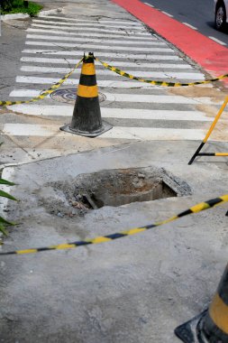 Salvador, Bahia, Brezilya - 16 Mayıs 2023: Koni ve güvenlik bandı Salvador şehrinin kaldırımında delik olan yerel işaret