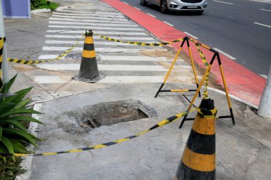 Salvador, Bahia, Brezilya - 16 Mayıs 2023: Koni ve güvenlik bandı Salvador şehrinin kaldırımında delik olan yerel işaret