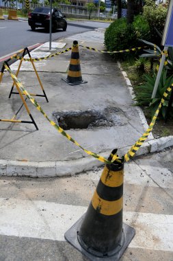 Salvador, Bahia, Brezilya - 16 Mayıs 2023: Koni ve güvenlik bandı Salvador şehrinin kaldırımında delik olan yerel işaret