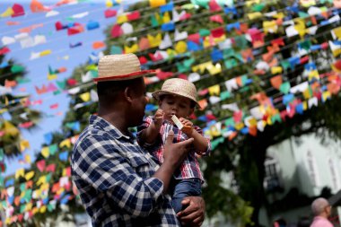 Salvador, Bahia, Brezilya - 26 Haziran 2022: Salvador şehrinin tarihi merkezi Pelourinho 'daki Sao Joao ziyafetinin dekorasyonunu çocuklar ziyaret ediyor.