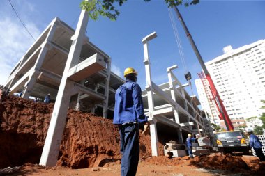 Salvador, Bahia, Brezilya - 9 Mayıs 2023: işçi Salvador 'da bir devlet okulunun inşası için bir ön-orta sınıf yapının kurulumunu denetliyor..