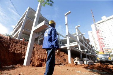 Salvador, Bahia, Brezilya - 9 Mayıs 2023: işçi Salvador 'da bir devlet okulunun inşası için bir ön-orta sınıf yapının kurulumunu denetliyor..