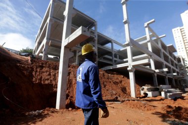 Salvador, Bahia, Brezilya - 9 Mayıs 2023: işçi Salvador 'da bir devlet okulunun inşası için bir ön-orta sınıf yapının kurulumunu denetliyor..