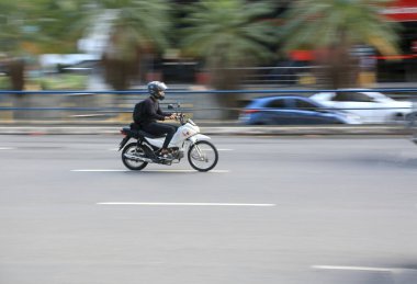 Salvador, Bahia, Brezilya - 11 Ağustos 2023: motosiklet sürücüsü Salvador şehrinde bir bulvardan geçerken görüldü..