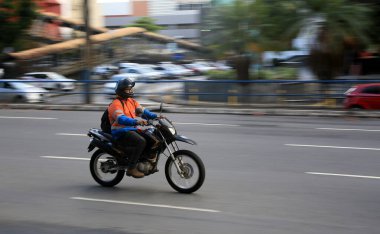 Salvador, Bahia, Brezilya - 11 Ağustos 2023: motosiklet sürücüsü Salvador şehrinde bir bulvardan geçerken görüldü..