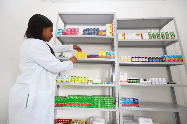 stock image lencois, bahia, brazil - may 26, 2024: pharmacist is seen next to a shelf of medicines in a pharmacy at a medical center in the city of Lencois.