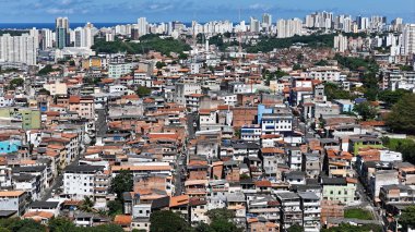 Salvador, Bahia, Brezilya - 29 Haziran 2024: Gecekondu mahallesindeki evlerin ve Salvador şehrindeki yerleşim yerlerinin havadan görünüşü.