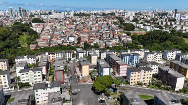Salvador, Bahia, Brezilya - 29 Haziran 2024: Gecekondu mahallesindeki evlerin ve Salvador şehrindeki yerleşim yerlerinin havadan görünüşü.