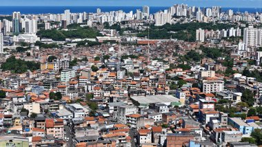 Salvador, Bahia, Brezilya - 29 Haziran 2024: Gecekondu mahallesindeki evlerin ve Salvador şehrindeki yerleşim yerlerinin havadan görünüşü.