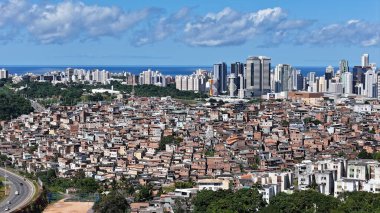 Salvador, Bahia, Brezilya - 29 Haziran 2024: Gecekondu mahallesindeki evlerin ve Salvador şehrindeki yerleşim yerlerinin havadan görünüşü.