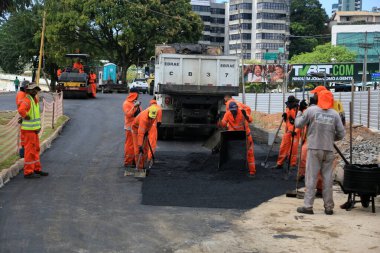 salvador, bahia, brazil - september 25, 2023: workers laying asphalt on a street in the city of Salvador clipart