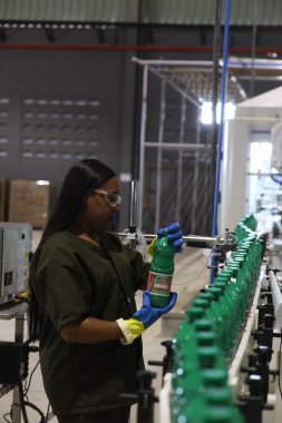 Mata de Sao Joao, Bahia, Brezilya - 15 Nisan 2025: Bahia 'daki bir fabrikada kimyasal üretim bandında çalışan kadın.