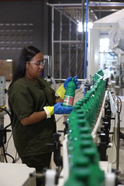 Mata de Sao Joao, Bahia, Brezilya - 15 Nisan 2025: Bahia 'daki bir fabrikada kimyasal üretim bandında çalışan kadın.