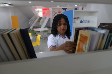 Amerika Dourada, Bahia, Brezilya - 2 Mayıs 2025: Bahia 'da bir devlet okulundan bir öğrenci okul kütüphanesinde görüldü..