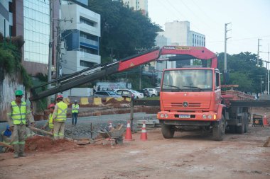 Salvador, Bahia, Brezilya - 29 Temmuz 2022: Salvador 'daki Lucaia Kanal Bölgesi' nde BRT ulaşım sisteminin özel şeridinde çalışan işçilerle dolu munck kamyonu.