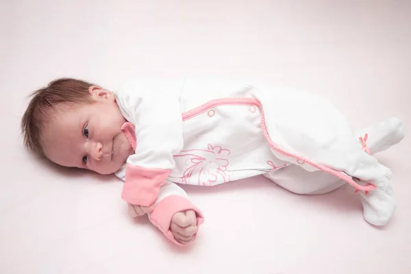 stock image Newborn baby girl on a pink background. Concept of love and care.