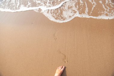 Deniz kıyısındaki kumda ayak sesleri.