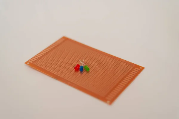 3つのLed異なる色の明確な背景を持つ赤のプロトタイピングボード — ストック写真