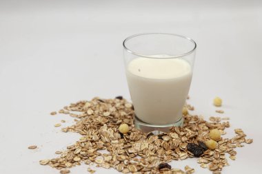 Beyaz arka planda süt ve müsli bardakları.