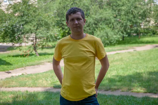 Parkta sarı tişörtlü genç bir adam..