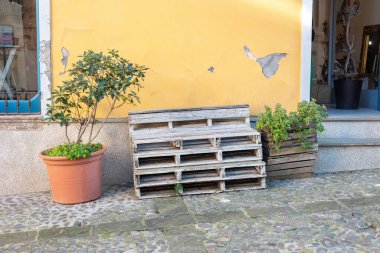 Paletlerden yapılmış çok yüksek bir bank, geri dönüşümlü bir mobilya parçası.