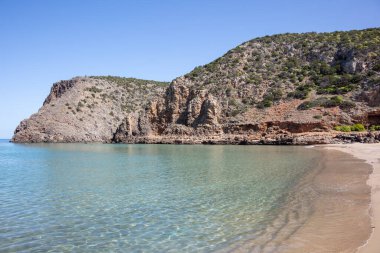 Sahildeki tepelerin manzarası, yamaçtaki bataklıklar ve çalılar.