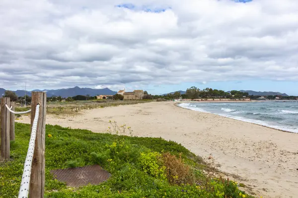 Plaj, arka planda görünen kilise, Chiesa Romanica di Sant 'Efisio - Nora, eski kilise deniz kıyısında, Sardunya, İtalya