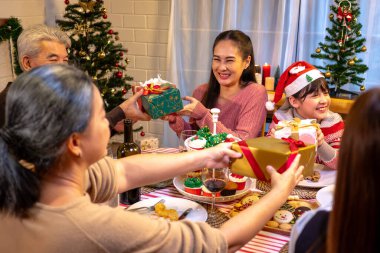 Mutlu insanlar Noel 'i ve evde yeni yılı masa yemeğinde kutluyorlar. Neşeli büyük, kız, kız, oğul ve çocuk, yeni yıl tatili mutlu geçtiğinde, mutlu bir Noel süsüsüyle akşam yemeği yiyorlar..