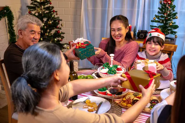 Mutlu insanlar Noel 'i ve evde yeni yılı masa yemeğinde kutluyorlar. Neşeli büyük, kız, kız, oğul ve çocuk, yeni yıl tatili mutlu geçtiğinde, mutlu bir Noel süsüsüyle akşam yemeği yiyorlar..