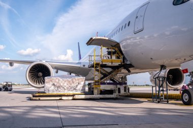 Hava kargo lojistik konteynerleri bir uçağa yükleniyor. Hava taşımacılığı, havaalanındaki modern yük uçağına yüklenmeye hazır olun..