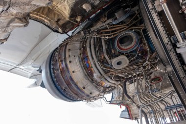 Uçak parkındaki bakım sırasında gaz türbini motoru kapanıyor. Tamirci ve teknisyen hidrolik tamiri ve elektrik santralinin kontrol sistemi..