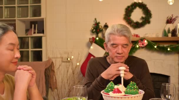 幸せな人々は 自宅でクリスマスと新年を過ごすときにテーブルの食事で祝っています 陽気な高齢者 娘と子供は幸せな新年の休日にメリーXmasの装飾で夕食を食べています — ストック動画