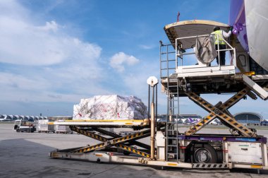 Hava kargo lojistik konteynerleri bir uçağa yükleniyor. Hava taşımacılığı, havaalanındaki modern yük uçağına yüklenmeye hazır olun..