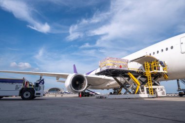 Hava kargo lojistik konteynerleri bir uçağa yükleniyor. Hava taşımacılığı, havaalanındaki modern yük uçağına yüklenmeye hazır olun..