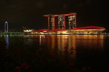 View of Singapore from Merlion Park, overlooking Marina Bay Sands. Boats gently glide across the water, while the lights of Marina Bay create stunning reflections on its surface. clipart