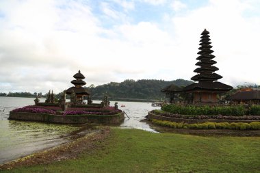 Bali Adası 'ndaki Pura Ulun Danu Batur Tapınağı. Sazdan çatılı Budist tapınağı. Göldeki tapınak. Etrafta bir sürü yeşillik var..