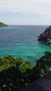 Kristal mavi su, yemyeşil tepeler ve eşsiz kaya oluşumlarıyla Similan Adası 'ndaki tropikal kıyı şeridinin panoramik görüntüsü..