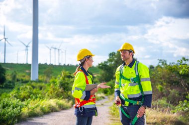 Rüzgar türbini çiftliğinde çalışan iki mühendis, sürdürülebilir enerji endüstrisi kavramı, iklim değişikliği için yenilenebilir enerji çözümü